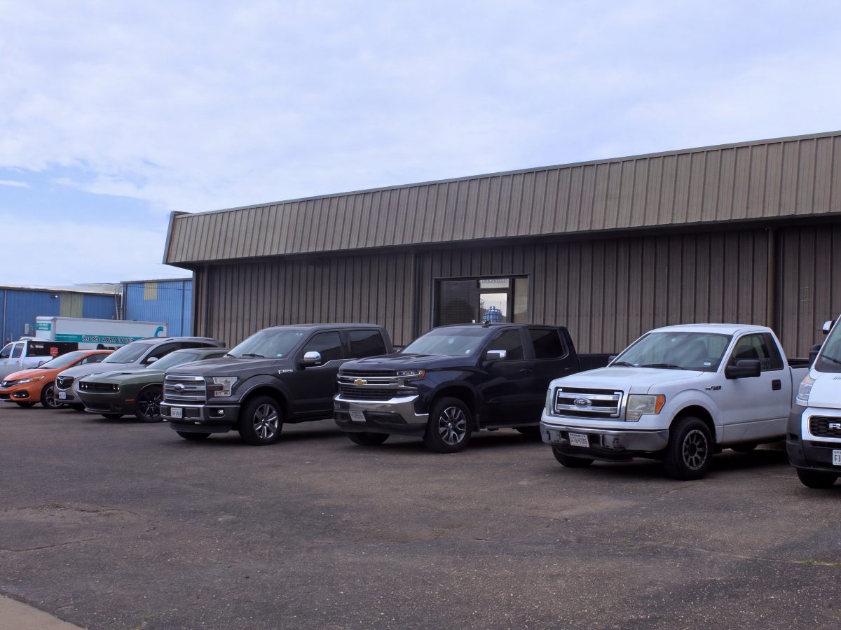 The United Auto Works building on Englewood Ave with customer vehicles parked along the front