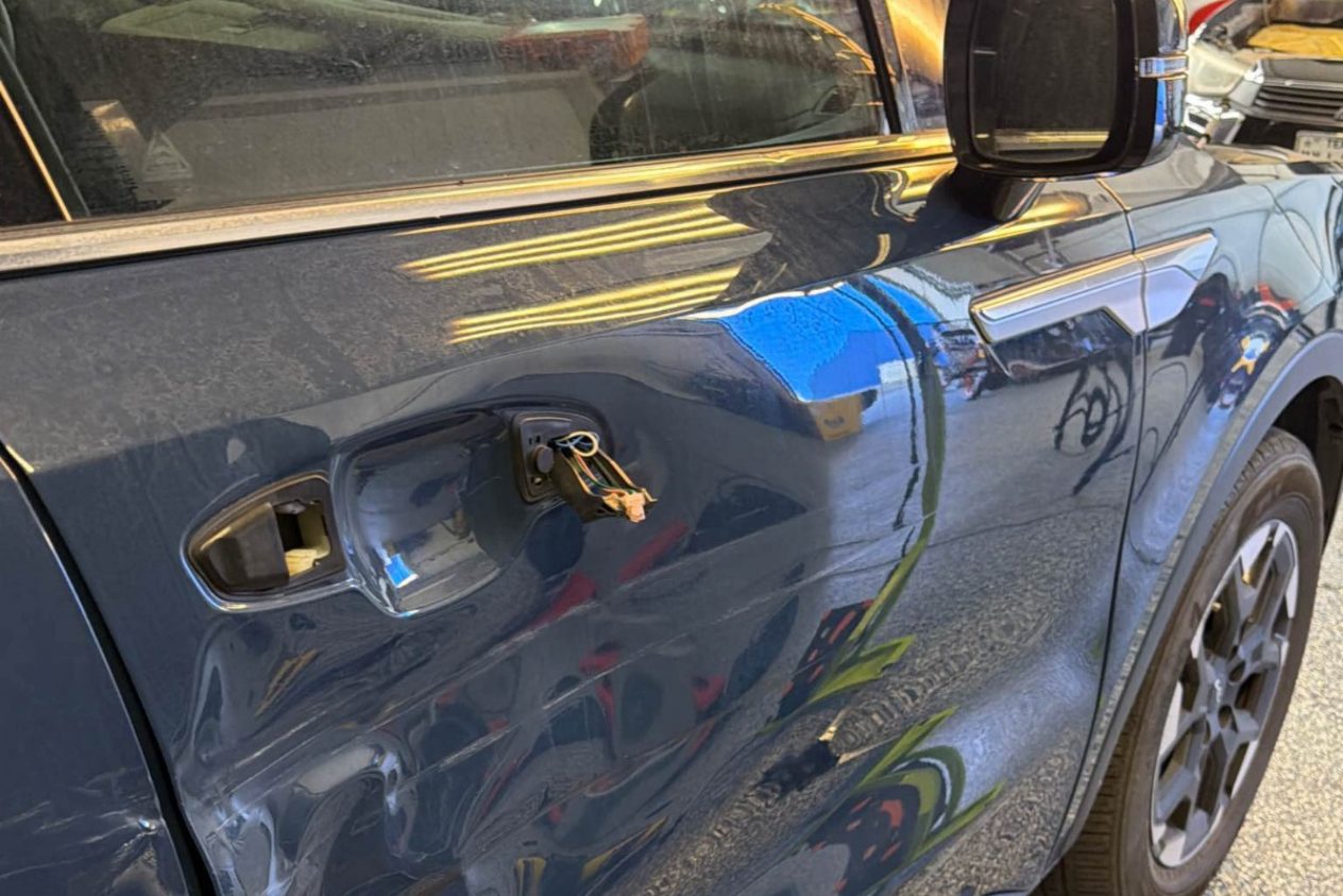 Before: a dented door and a damaged mirror on a dark blue SUV